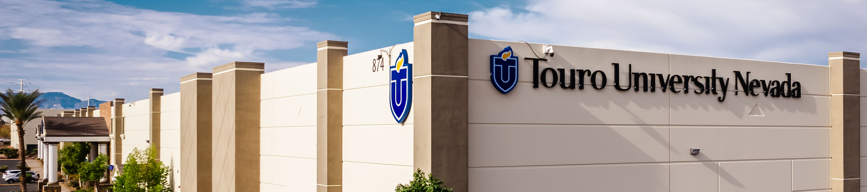 Exterior view of the front entrance of Touro University Nevada building, featuring the university logo